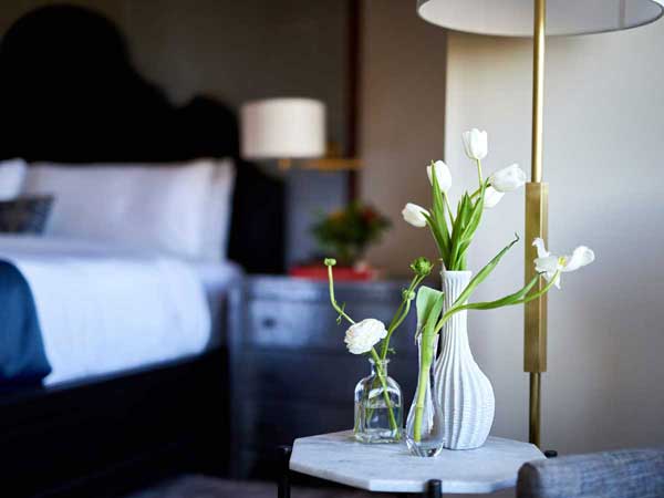 White flowers on a night stand.