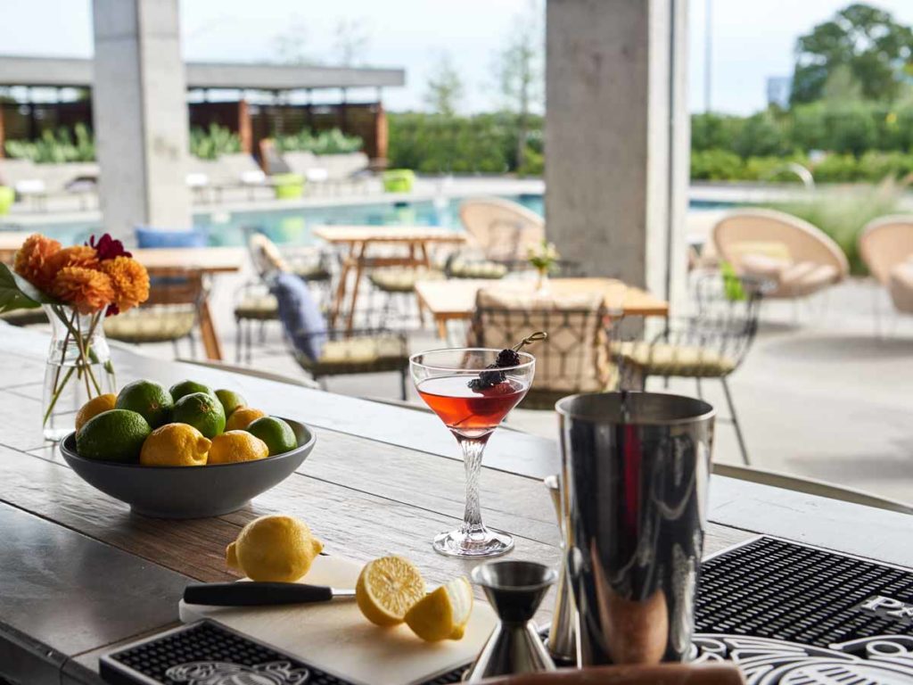 Exterior table with cocktail and pool in background.