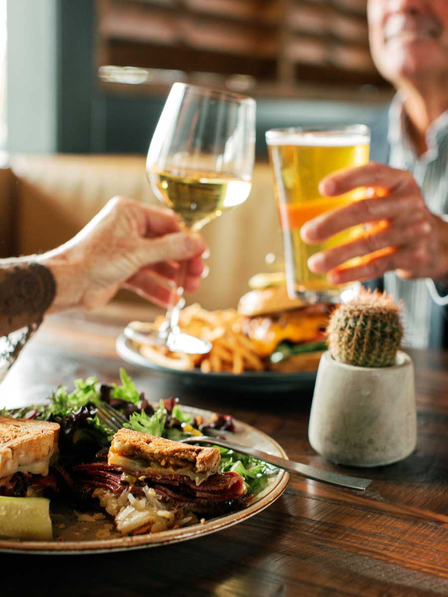 Couple toasting their meal with their drinks.